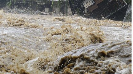 Un pan entier d'un h&ocirc;tel est emport&eacute; par la rivi&egrave;re Kinugawa sortie de son lit, jeudi 10 septembre 2015 &agrave; Nikko, dans la p&eacute;riph&eacute;rie nord de Tokyo (Japon). (KYODO NEWS / AP / SIPA)