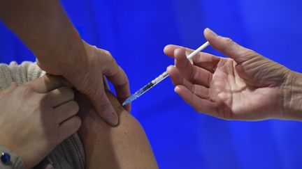 Une Britannique se fait vacciner contre le Covid-19, à Cardiff, au pays de Galles (Royaume-Uni), au premier jour du lancement de la campagne de vaccination, le 8 décembre 2020. (JUSTIN TALLIS / AFP)