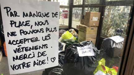 "Par manque de place, nous ne pouvons plus accepter les vêtements", stipule une feuille placardée sur le lieu de collecte de l'association Pazem. (ANNA JAUJARD / RADIOFRANCE)