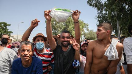 Des partisans du président tunisien&nbsp;Kaïs Saïd&nbsp;exhibent une couche de bébé le 26 juillet 2021, alors qu'ils sont rassemblés devant le bâtiment du Parlement tunisien au Bardo, dans la capitale Tunis, pour soutenir le&nbsp;chef de l'Etat&nbsp;après sa décision, entres autres, de geler les travaux de l'Assemblée.&nbsp; (CHEDLY BEN IBRAHIM / HANS LUCAS)