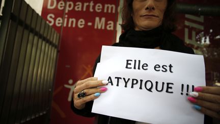 Une femme manifeste avec une affiche au slogan "Elle est atypique!!!" devant le Conseil départemental de la Seine-Maritime, le 21 juin 2018. (CHARLY TRIBALLEAU / AFP)