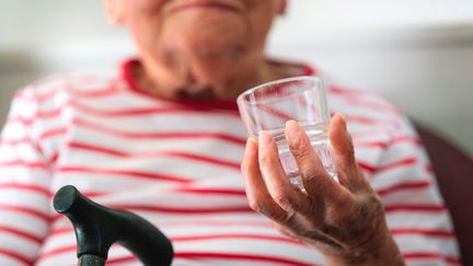 Une personne âgée boit un verre d'eau dans un Ehpad, le 11 juillet 2022. (JEREMIE FULLERINGER / MAXPPP)