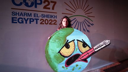 Les espoirs déçus de la COP 27, en Égypte&nbsp;à&nbsp;Sharm El-Sheikh,&nbsp;comme à chaque&nbsp;conférence mondiale sur le climat. Symbole de cette amertume&nbsp;et de cette déception, cette Terre qui suffoque, affichée par une militante de la cause environnementale et des droits humains, le 19 novembre 2022.&nbsp; (SEDAT SUNA / MAXPPP)