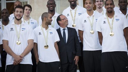 Le pr&eacute;sident fran&ccedil;ais Fran&ccedil;ois Hollande (C) pose avec les basketteurs de l'&eacute;quipe de France sur le perron du palais de l'Elys&eacute;e &agrave; l'occasion d'une r&eacute;ception donn&eacute;e en l'honneur de leur titre de champion d'Europe, Paris, le 23 septembre 2013. (MAXPPP)