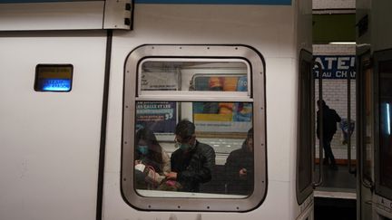 Des passagers portent des masques de protection dans le métro parisien, vendredi 13 mars 2020. (ABDULMONAM EASSA / AFP)