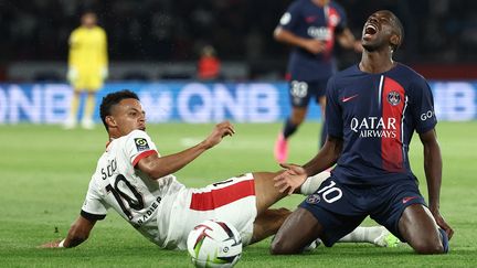 La souffrance d'Ousmane Dembélé, sur un tacle du Niçois Sofiane Diop, lors du match de la 5e journée de Ligue 1 entre le PSG et Nice, le 15 septembre 2023. (FRANCK FIFE / AFP)