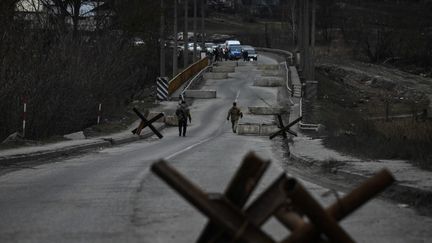 Des soldats ukrainiens sur le pont qui connecte la ville de Stoyanka à celle de Kiev, le 6 mars 2022. (ARIS MESSINIS / AFP)