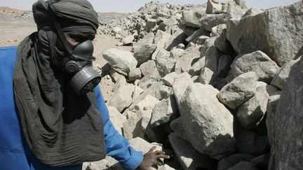 Un employé de la mine d'uranium à ciel ouvert de Arlit dans le désert nigérien, inspecte des roches contenant de l'uranium qui sert de combustible nucléaire. (Photo AFP/Pierre Verdy)