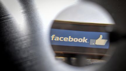 Le logo "Facebook vu à travers une loupe. (LOIC VENANCE / AFP)