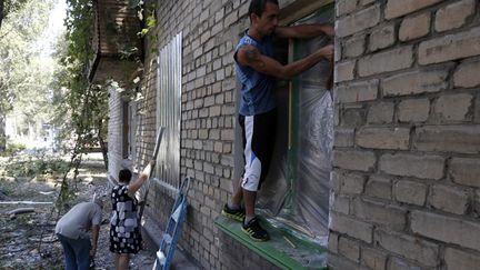  (Samedi à Donetsk, des habitants tentent de protéger leurs maisons avec des tôles de fer © REUTERS / Sergei Karpukhin)