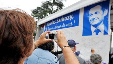 Des supporters de Nicolas Sarkozy lui &eacute;crivent des messages de soutien, &agrave; l'occasion de la F&ecirc;te de la violette, le 5 juillet 2014 &agrave; La Fert&eacute;-Imbault (Loir-et-Cher).&nbsp; (GUILLAUME SOUVANT / AFP)