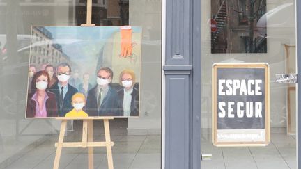 Photo prise le 22 mars 2020 à Paris montrant une peinture représentant des personnes avec des masques protecteurs dans une galerie d'art caprès la fermeture des galeries d'art le 19 mars 2021 pour limiter la propagation du COVID-19&nbsp; (LUDOVIC MARIN / AFP)