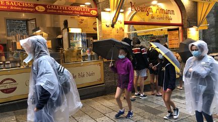 Des promeneurs affrontent la pluie à Saint-Malo (Ille-et-Vilaine), le 12 août 2020. (SANDRINE MULAS / HANS LUCAS / AFP)