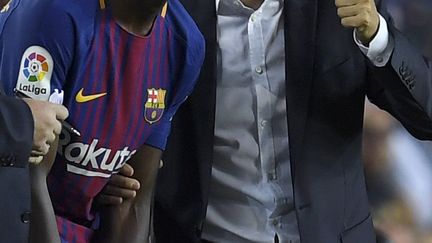 Ousmane Dembélé échange avec l'entraîneur du FC Barcelone, Ernesto Valverde, avant son entrée en jeu. (LLUIS GENE / AFP)