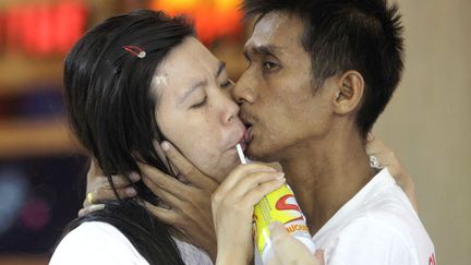 Un couple boit une boisson &eacute;nergisante tandis qu'il tente de remporter le concours du plus long baiser organis&eacute; &agrave; Pattaya (Tha&iuml;lande), le 14 f&eacute;vrier 2012. (SAKCHAI LALIT /AP / SIPA)