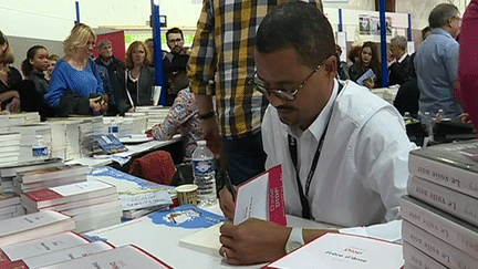 David Diop en séance de dédicaces à la 37e Foire du livre de Brive 
 (Capture d&#039;image France 3/Culturebox)