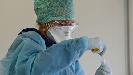 Une biologiste analyse un échantillon dans un centre de dépistage, à Lens&nbsp;(Pas-de-Calais), le 18 mai 2020. (DENIS CHARLET / AFP)