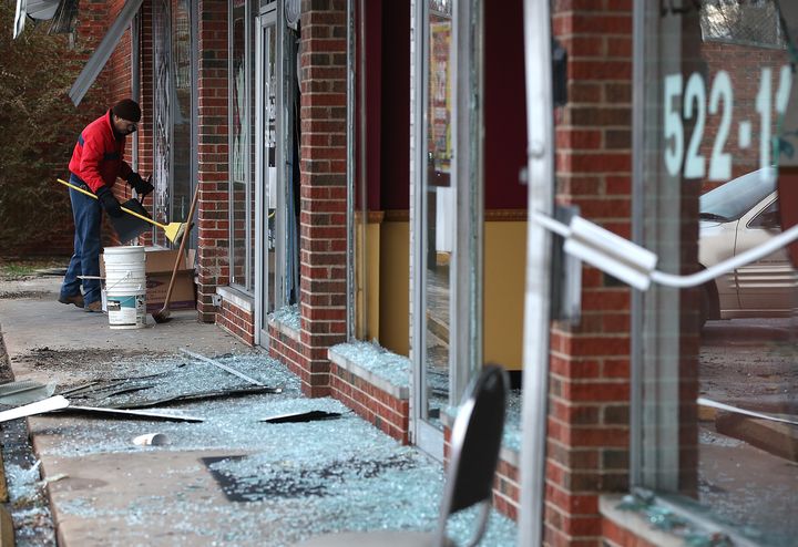 Un homme nettoie les d&eacute;bris de baies vitr&eacute;es fracass&eacute;es, &agrave; Dellwood.&nbsp;Barack Obama et les parents de Michael Brown avaient appel&eacute; au calme, lundi, avant l'annonce de la d&eacute;cision du grand jury. (JUSTIN SULLIVAN / GETTY IMAGES NORTH AMERICA)