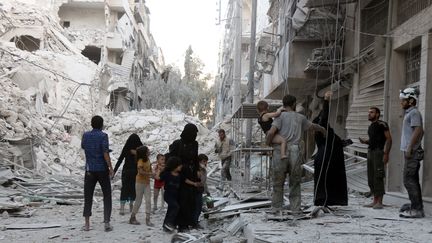 Une famille syrienne à Alep, après un bombardement le 23 septembre 2016 (THAER MOHAMMED / AFP)