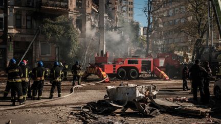 Des pompiers ukrainiens tentent d'éteindre un incendie après une attaque de drone russe, le 17 octobre 2022, à Kiev. (YASUYOSHI CHIBA / AFP)