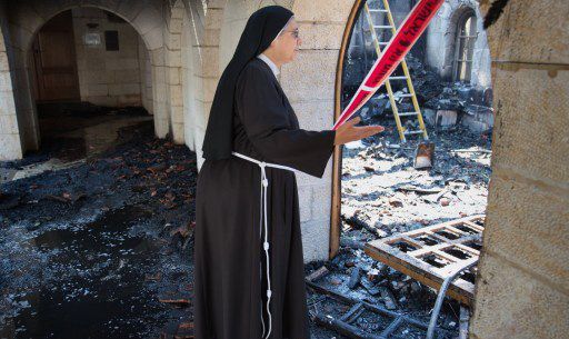 Juin 2015. Une soeur constate les dégats dans l'église de la multiplication des pains à Tibériade, en Israël, après une attaque contre ce symbole chrétien (MENAHEM KAHANA / AFP)