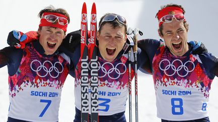 Les skieurs russes&nbsp;Maxim Vylegzhanin, Alexander Legkov et&nbsp;Ilia Chernousov fêtent leur podium historique en 50 km libre de ski de fond aux Jeux olympiques de Sotchi, le 23 février 2014. (CARLOS BARRIA / REUTERS)