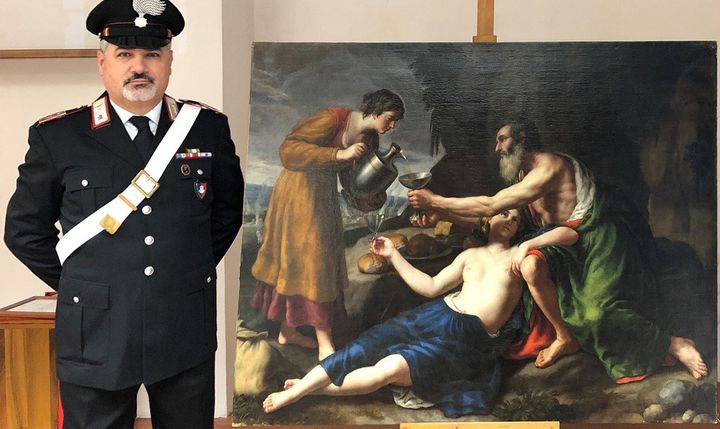 Un carabinier italien posté à côté du tableau de Poussin "Loth avec ses deux filles lui servant à boire" (photo publiée le 1er avril 2021) (HANDOUT / CARABINIERI PRESS OFFICE / AFP)