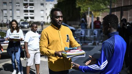 A la cité des Fusains, à Aubervilliers, le rappeur Mac Tyer offre des fournitures scolaires le 1er septembre 2018.
 (STEPHANE DE SAKUTIN / AFP)