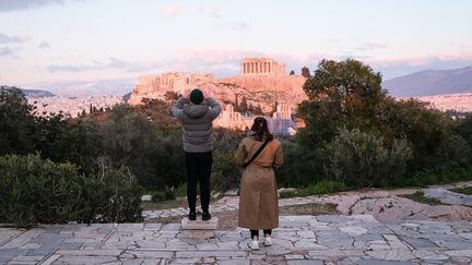 Des personnes prennent des photos de l'Acropole à Athènes (Grèce), le 11 février 2023. (NIKOLAS KOKOVLIS / NURPHOTO / AFP)