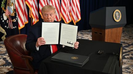 Donald Trump lors de la signature des quatre décrets, le 8 août 2020, à Bedminster, dans le New Jersey (Etats-Unis). (JIM WATSON / AFP)