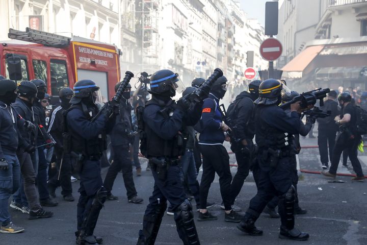 Des gendarmes armés de lanceurs Cougar et un CRS équipé d'un PGL-65, le 20 avril 2019, à Paris, lors d'une manifestation des "gilets jaunes". (ZAKARIA ABDELKAFI / AFP)