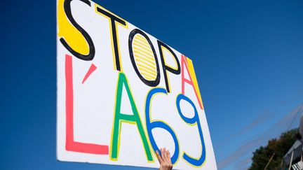 Un militant brandissant un panneau "Stop à l'A69" à Saïx (Tarn), le 21 octobre 2023. (ANTOINE BERLIOZ / HANS LUCAS / AFP)