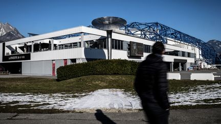 Une personne passe devant la salle olympique d'Albertville (Savoie), le 19 janvier 2022. (JEFF PACHOUD / AFP)