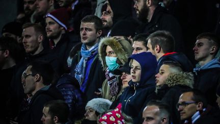 Une supportrice portant un masque de protection dans le&nbsp;public d'un match de Ligue 1 de football entre Metz et Nîmes, le 7 mars 2020. (MAXPPP)