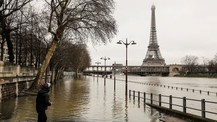 Un homme s'approche de la Seine en crue à Paris, le 23 janvier 2018. (LUDOVIC MARIN / AFP)