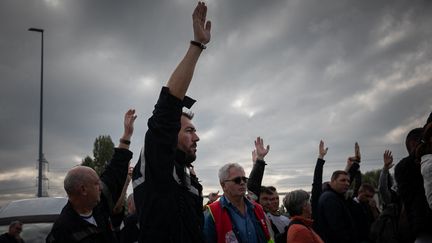 Des syndicalistes de la CGT et des employés se rassemblent à côté du site de la raffinerie TotalEnergies, à Gonfreville-l'Orcher, près du Havre, le 10 octobre 2022. (LOU BENOIST / AFP)