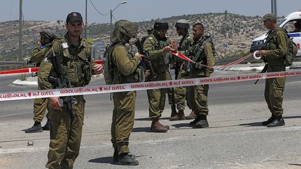 Des soldats isra&eacute;liens montent la garde le 15 ao&ucirc;t 2015 en Cisjordanie apr&egrave;s une attaque &agrave; l'arme blanche contre l'un d'entre eux. (AHMAD GHARABLI / AFP)