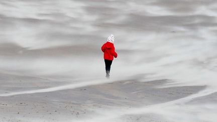 Un enfant marche sur la sable alors que des vents violents balaient la c&ocirc;te &agrave; Seaburn (Royaume-Uni), le 3 janvier 2012. (SCOTT HEPPELL / AP / SIPA)