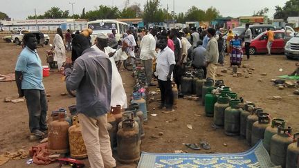 Des Soudanais attendent l'arrivée d'un camion de gaz pour échanger leurs bidons vides, à Wad Madani, au Soudan, le 14 juin 2023. (AFP)