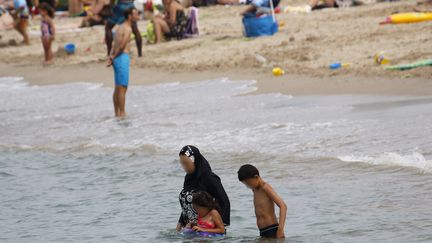 Une femme en burkini et ses deux enfants se baignent sur une plage de Marseille, le 17 août 2016. (REUTERS)