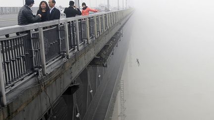 Un corps tombe du grand pont de Nankin sur le Yangts&eacute;, quelques minutes apr&egrave;s qu'une personne s'est d&eacute;j&agrave; jet&eacute;e dans le fleuve &agrave; Wuhan (Chine), le 27 mars 2013. (AFP)