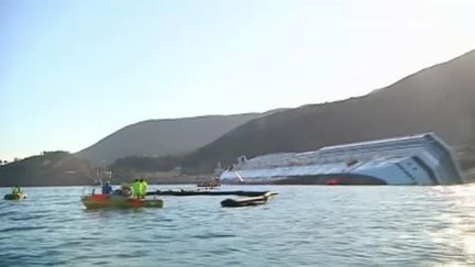 Des barrages flottants d&eacute;ploy&eacute;s autour de l'&eacute;pave du "Costa Concordia", le 20 janvier 2012 (FTVi / APTN)