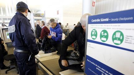 Un policier r&eacute;quisitionn&eacute; proc&egrave;de &agrave; un contr&ocirc;le de s&eacute;curit&eacute; &agrave; l'a&eacute;roport Roissy-Charles-de-Gaulle, le 22 d&eacute;cembre 2011. (FRAN&Ccedil;OIS GUILLOT / AFP)