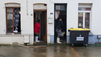 Des habitants d'Arques, dans le nord de la France, évacuent l'eau de leurs habitations, après les inondations qui ont eu lieu le 4 janvier 2024. (DENIS CHARLET / AFP)