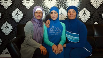 La créatrice du burkini, Aheda Zanetti (G) pose avec deux jeunes femmes portant son invention dans sa boutique de Sydney (Australie), le 20 août 2016. (SUBEL BHANDARI / DPA / AFP)