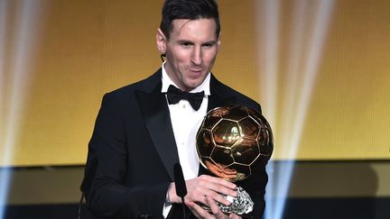 Lionel Messi pose avec son cinquième Ballon d'Or (FABRICE COFFRINI / AFP)