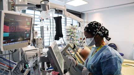 Une infirmière s'occupe d'un patient au service de soins intensifs pour les patients infectés par le Covid-19 à l'hôpital AP-HP Tenon, le 26 janvier 2021 à Paris. (ALAIN JOCARD / AFP)