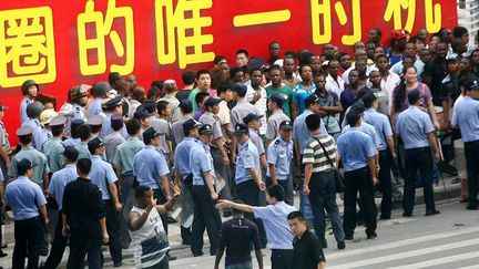 Des policiers chinois encadrent des Africains à Canton lors d'une manifestation en 2009 (photo d'archives). (Alex LEE / REUTERS)