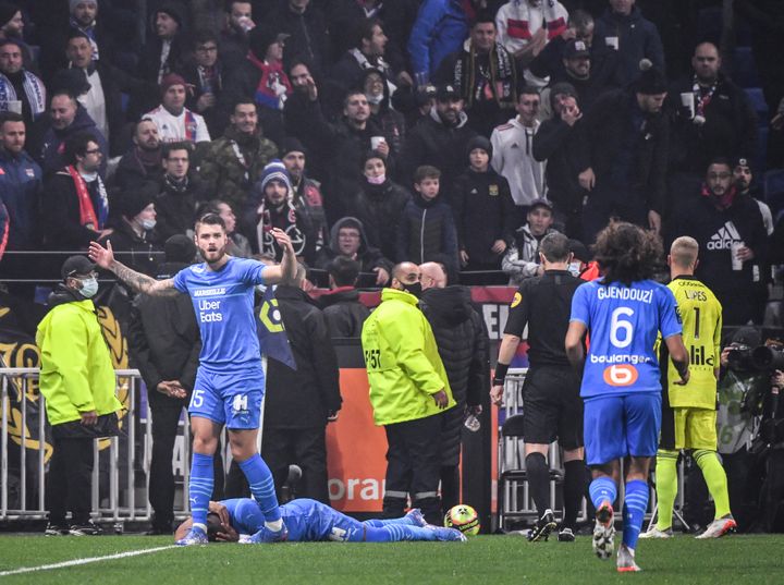 Dimitri Payet on the ground, hit by a full bottle of water thrown from the stands of the Groupama Stadium in Lyon, during OL-OM on November 21, 2021. (PHILIPPE DESMAZES / AFP)