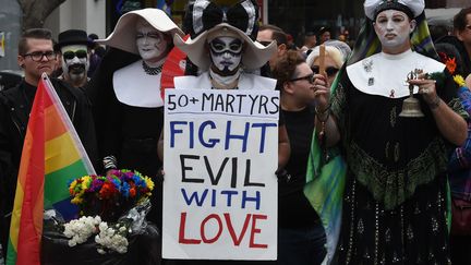 A Los Angeles (Californie), un participant à la Gay Pride porte une pancarte "Combattre le mal avec de l'amour", le 12 juin 2016. (MARK RALSTON / AFP)